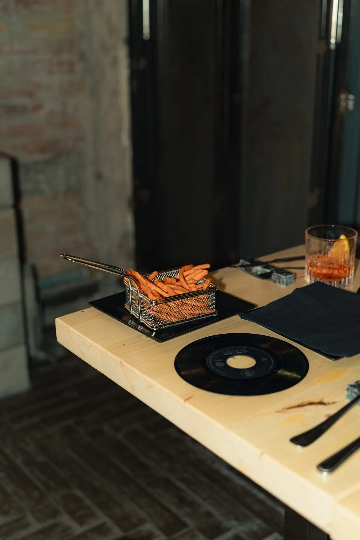 Patata dolce stick e cocktail al tavolo con vinile come sottopiatto